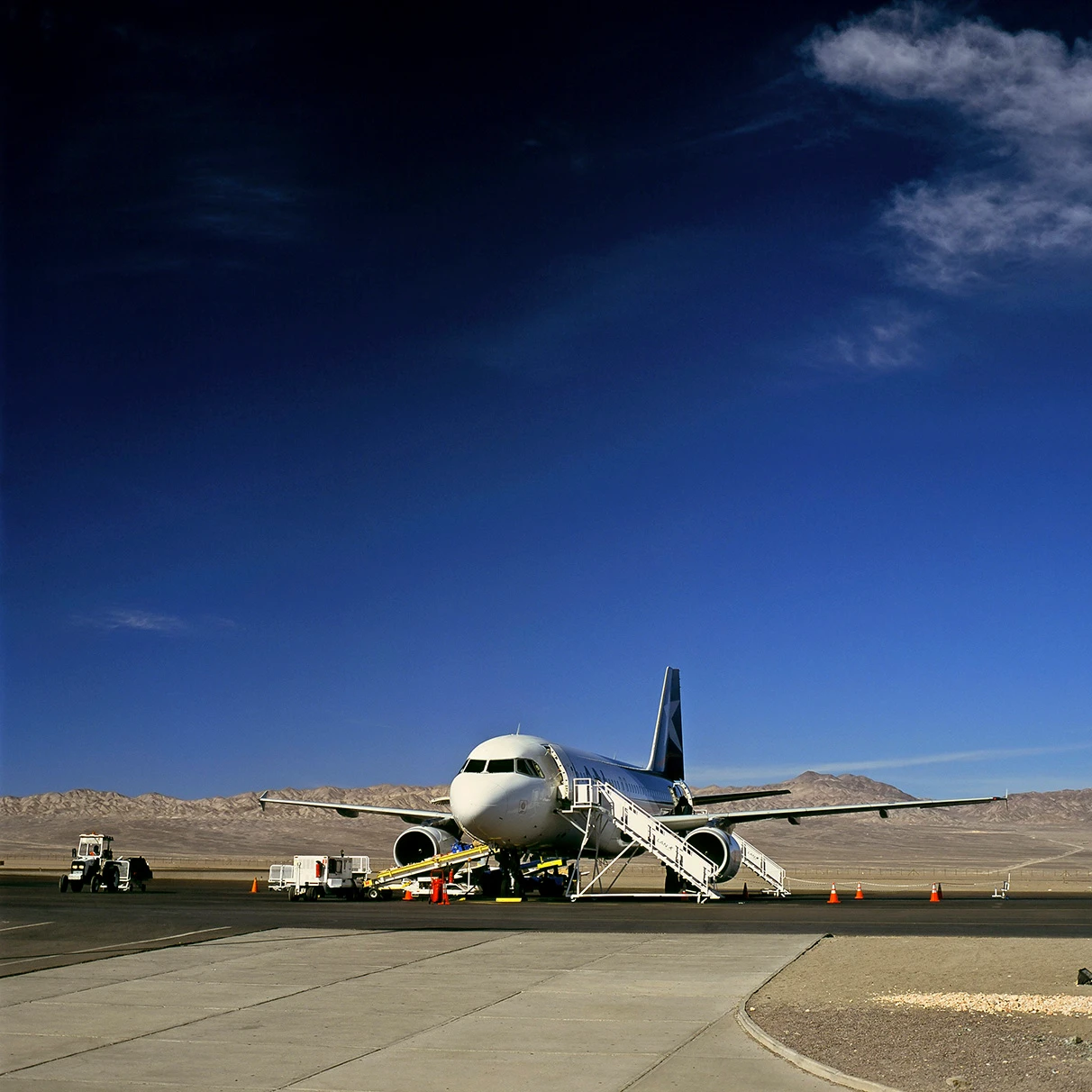 Ein Flugzeug steht auf der Landebahn mit trockener Landschaft im Hintergrund in Argentinien während einer Land Rover Experience Tour, aufgenommen mit Hasselblad 501c FarbDia-Film.