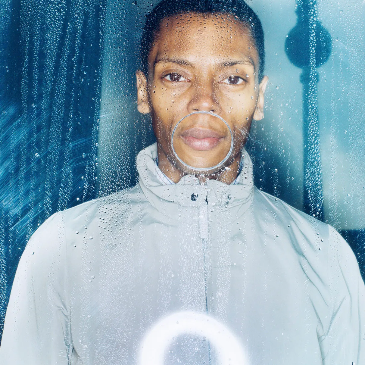 Der amerikanische DJ Jeff Mills posiert hinter einer Plexiglasplatte mit Wassertropfen in Berlin am Alexanderplatz mit Fernsehturm im Hintergrund, aufgenommen mit Hasselblad 501c FarbNegativ-Film