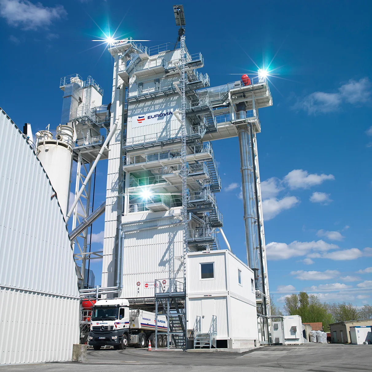 Das neue moderne Asphalt- Mischwerk Schönerlinde bei strahlendem Sonnenschein und blauem Himmel. Weit oben im MIschwerk angebrachte Blitzköpfe sorgen mit ihrem Gegenlicht für Effekt- Hascherei. Produziert für Eurovia AMW Schönerlinde mit Hasselblad 501c CFV 16.