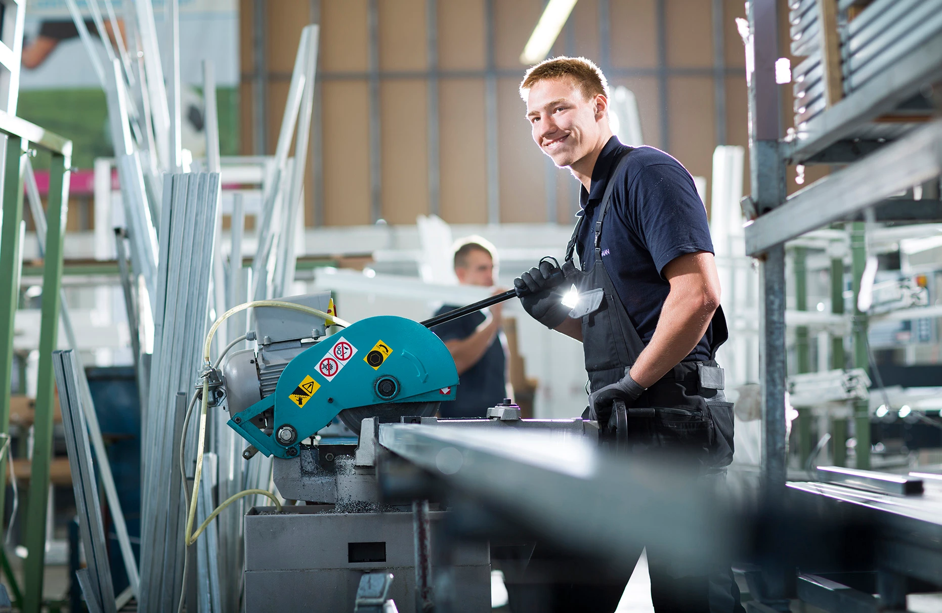 Ein Mitarbeiter steht arbeitend an einer Maschine in einer Werk- Halle der Firma meban aus Neubrandenburg. Produziert für eine Kampagne der Fensterbau- Firma Meban.