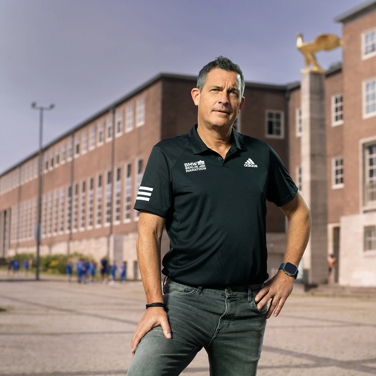Jürgen Lock- CEO von SCC Events GmbH, posiert vor einem historischen Gebäude des Berliner Olympia-Stadion mit Stele und goldenem Adler. Produziert für Runners World Magazin mit Hasselblad 501c CFV 16.