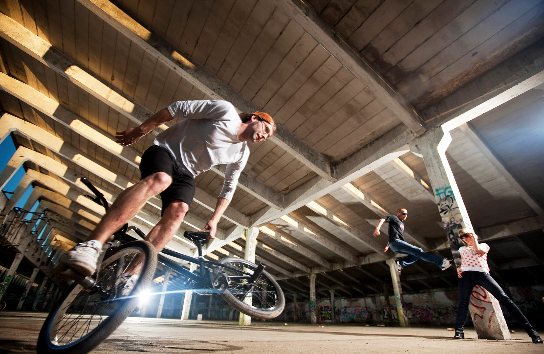 Der BMX-freestyle Fahrer Steffen "Wenkman zeigt einen seiner flatland- Tricks in einer stillgelegten alten Industriehalle. Die Halle ist von Sonne und Kunstlicht ausgeleuchtet. Eine Freie Arbeit.