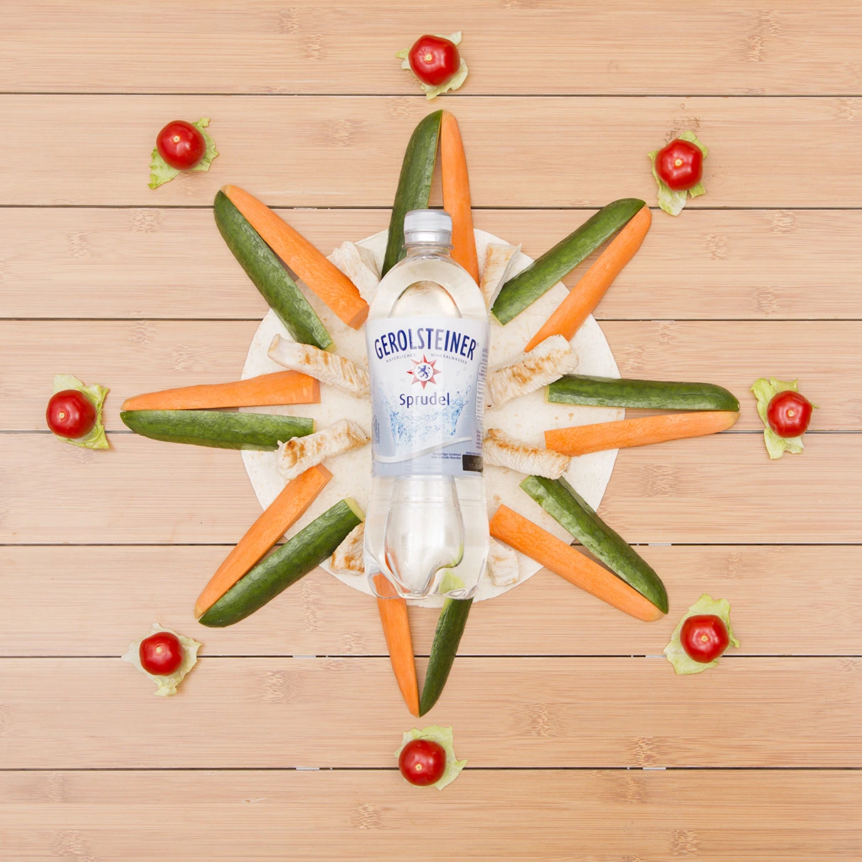 Eine Gerolsteiner Sprudel PET-Flasche liegt zusammen mit zu einem Gerolsteiner ähnlich gelegtem Stern auf Holzlatten Untergrund und das ganze ist von oben im flat lay Stil fotografiert . Produziert für die PR-Agentur Schröder und Schömbs PR aus Berlin.